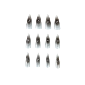 Y2K stiletto press-on nails with black ombre, silver star patterns, and rhinestones