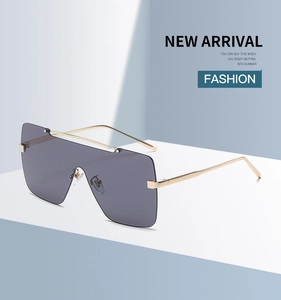 Details einer quadratischen Übergroßen Sonnenbrille mit goldenen Metallbügeln und Gläsern