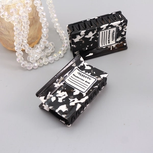 Black and white terrazzo hair claws with Composition Book print on light background