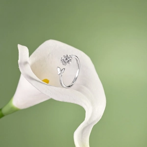 Detailed close-up of a silver leaf ring with zircon stones on a white lily flower