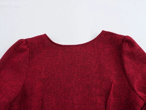 Dettaglio del girocollo e delle maniche a sbuffo su vestito in tweed bordeaux da donna