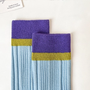 Close-up of ribbed texture on tricolor mid-calf cotton socks in purple, yellow and blue