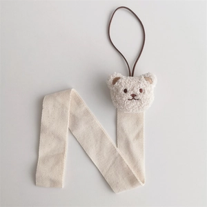 Close-up of a white plush bear wall hanging organizer made of cotton linen ribbon
