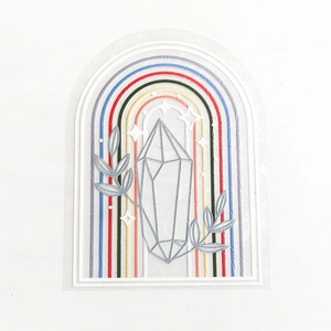 Close-up of a rainbow suncatcher window sticker with colorful crystal and leaf patterns
