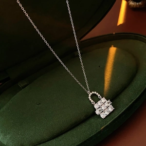 Macro di una collana con ciondolo a lucchetto in zircone argento in scatola di velluto