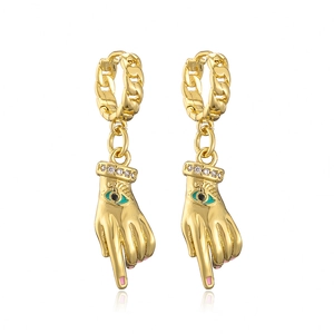 Macro detail of gold-plated palm earrings with zircon cuff and blue evil eye design