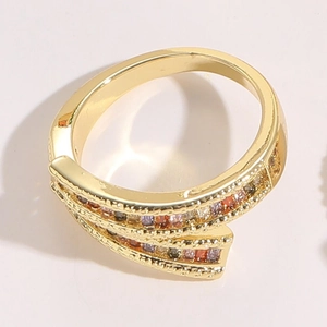 Macro detail of gold-plated wrap ring featuring multi-colored square-cut zircon stones
