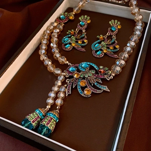 Macro view of vintage peacock jewelry set with colorful crystals and fringe details
