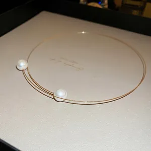 Minimalist double-layer golden metal wire choker with elegant white pearls on both ends