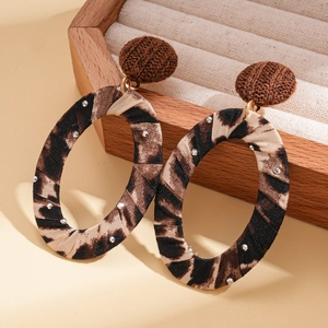 Detail of leopard print oval earrings with brown woven studs and small crystal accents