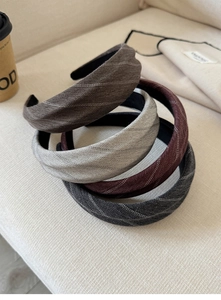 Detail of four herringbone fabric headbands in brown, gray, burgundy, and charcoal colors