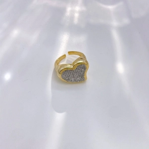 Elegant gold heart ring with pavé zircons on a white rippled background