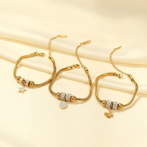 Three gold snake chain bracelets with star, round, and butterfly charms and zircons