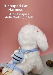 Detail of light blue corduroy cat harness with a plush bee decoration and golden D-ring