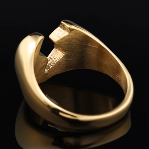 Macro detail of golden geometric ring showing polished surface and brushed inner texture