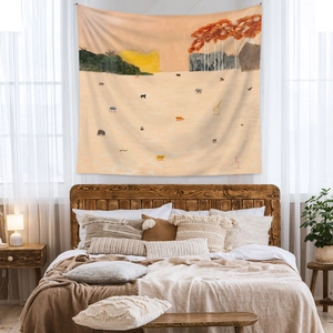 Detail of bohemian tapestry featuring wild animals hanging above a cozy bedroom bed