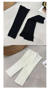 Detailed knit texture of ribbed leg warmers in black and beige with rolled edges