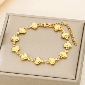 Detailed view of polished golden heart-shaped links and adjustable lobster clasp on bracelet