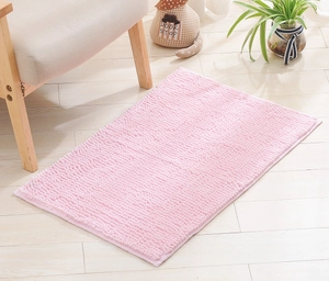 Pink chenille bathroom rug with absorbent noodle texture on a light wood floor