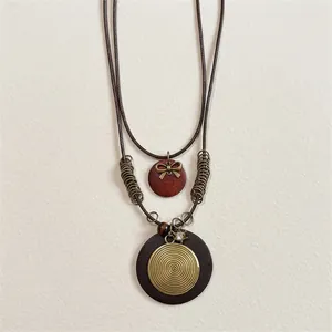 Vintage ethnic style long necklace with wood beads and tassel on a traditional wood tray