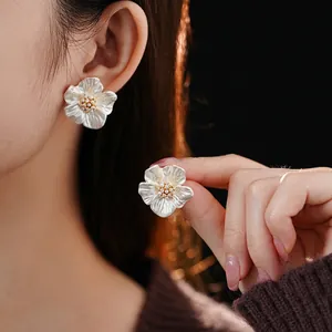 Elegant gold plated flower stud earrings with white pearl petals and zircon center