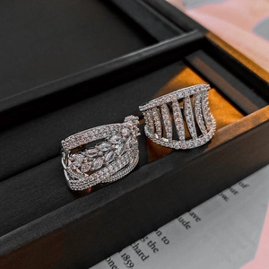 Macro detail of silver hollow rings with marquise zircon stones on black texture