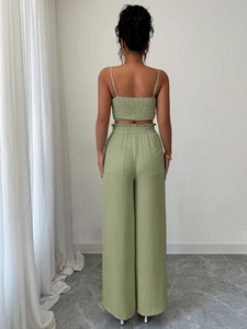 Vista posteriore dell'elegante completo verde polvere con top a punto smock e pantaloni larghi