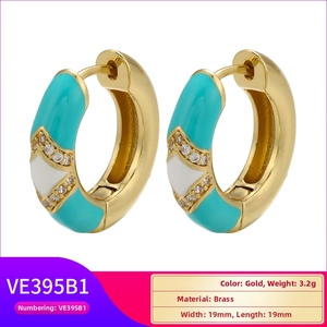 Detailed view of gold rectangle earrings with turquoise enamel and cubic zirconia