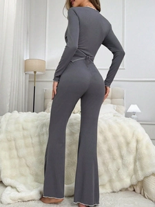 Detailed back view of grey knit lounge set featuring ribbon tie waist and contrast wavy trim