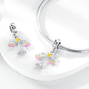 Macro shot of silver Libra zodiac charm with pink enamel and sparkling colorful zircons