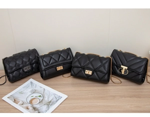 Detail view of four black quilted PU leather shoulder bags with various gold chain straps