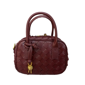 Mini burgundy woven leather boston bag with twin handles and golden knot charm