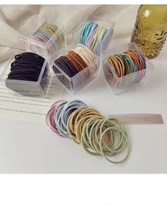 Detail of high-elastic spiral hair ties in transparent jars with colorful striped textures