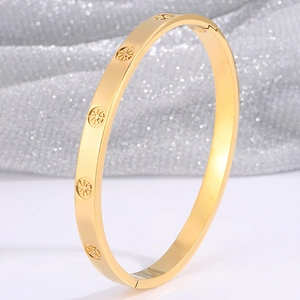 Detail view of gold-plated stainless steel bangle with engraved sunburst pattern