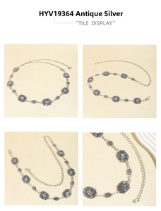 Detail of antique silver metal chain belt featuring embossed floral patterns and lobster clasp