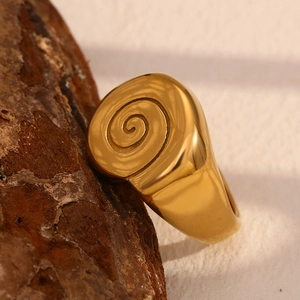 Detailed view of an 18K gold plated stainless steel ring with spiral sea shell texture