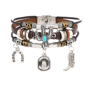 Detail of Western cowboy leather bracelet featuring horseshoe and cactus metal charms