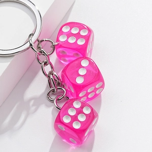 Portachiavi con tre dadi rosa traslucidi e anello metallico su sfondo bianco