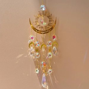 Detail of sun and moon crystal suncatcher reflecting rainbows on a minimalist wall
