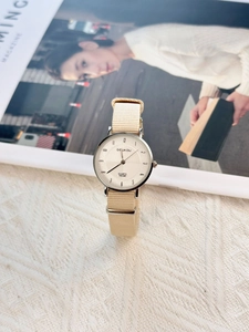 Minimalist quartz watch with beige nylon strap on soft knit fabric for a cozy style