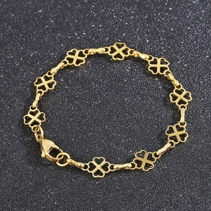Detailed view of a gold clover charm bracelet with hollow design and lobster clasp closure