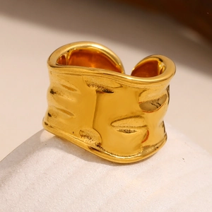 Macro shot of 18K gold plated chunky ring featuring irregular textured metal surface