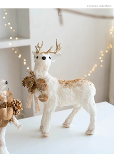 Detail of white reindeer figurine with gold glitter antlers and rustic pinecone collar