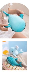 Detail of whale plush toy featuring skin-friendly soft fabric and product washing label