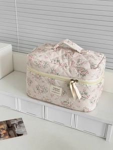 Dettaglio della trousse trapuntata rosa a fiori con cerniera e manico in tessuto