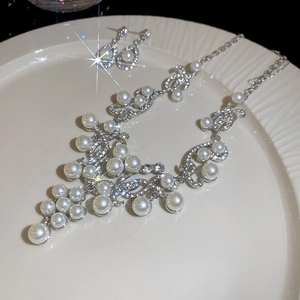 Macro shot of French style water drop pearl necklace and earrings set with crystal rhinestones