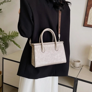 Vintage champagne textured leather tote bag with wide strap shown in a modern home setting