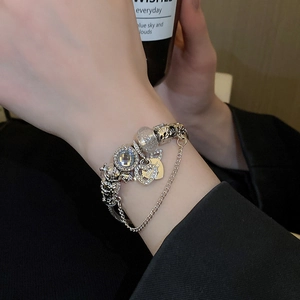 Close-up of silver-tone beaded bracelet featuring heart charm and faceted crystals