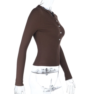 Detailed side view of brown ribbed long sleeve top with white buttons on mannequin