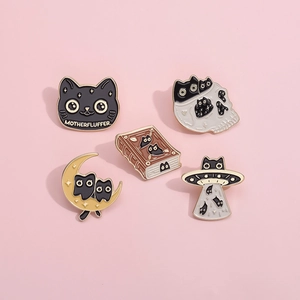 Detail view of five assorted black cat enamel pins including UFO and moon designs